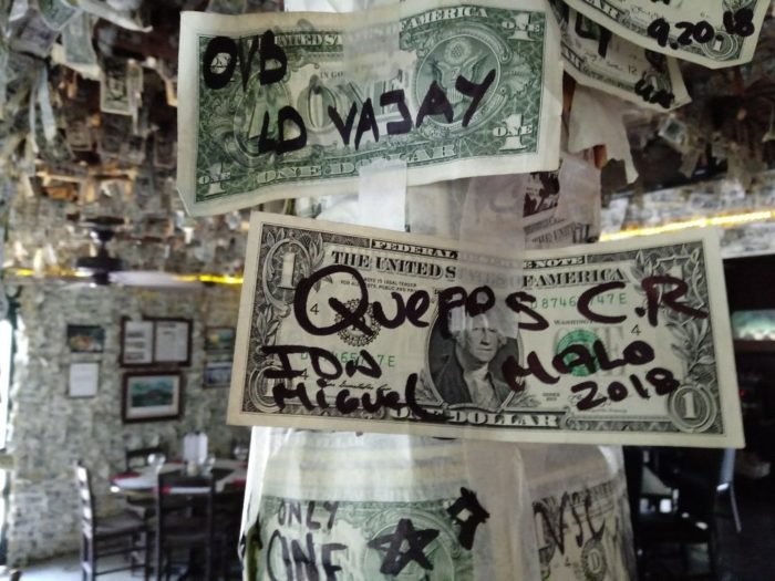 close up of autographed dollar bills on taped to beam