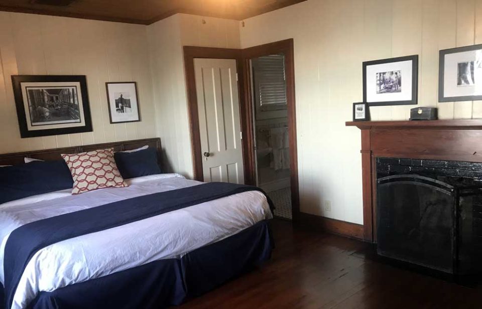 Quaint, refurbished room at Cabbage Key Inn with original wooden floors, fireplace, and king-sized bed